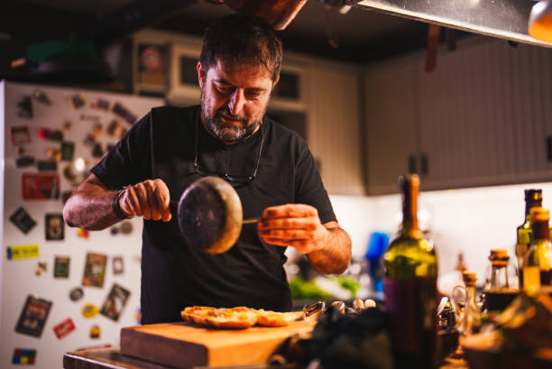 istock Man pouring sauce on bread in his kitchen 1822164600
