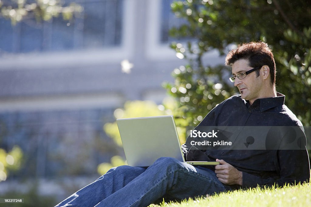 Człowiek z laptopa na kampusie Trawnik - Zbiór zdjęć royalty-free (Laptop)