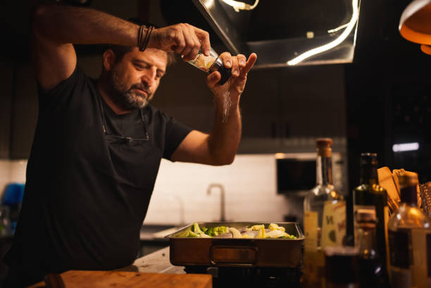 Man adding spice from the salt grinder to the food