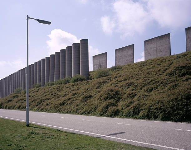 istock Large concrete sound barrier alongside road. 182217773