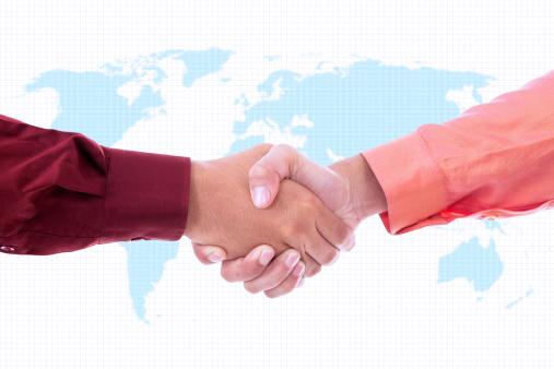 Two businessmen handshaking on world map background