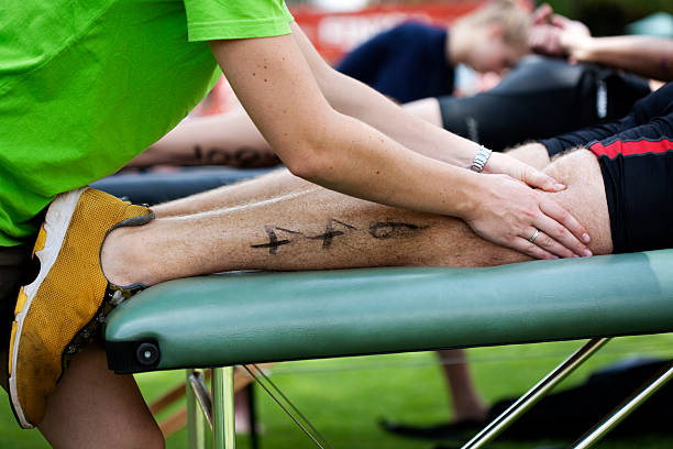 Santa Monica, California, USA - March 15, 2015: A runner who moments earlier finished the Los Angeles Marathon lies on his front in a volunteer massage tent to receive a massage. Santa Monica, California