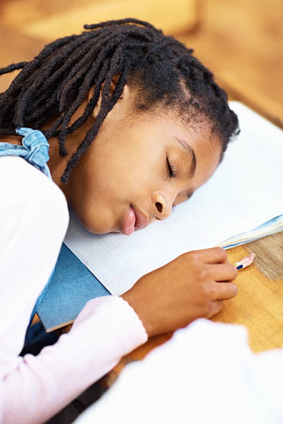 istock Tired African American girl sleeping on her notes 182218435