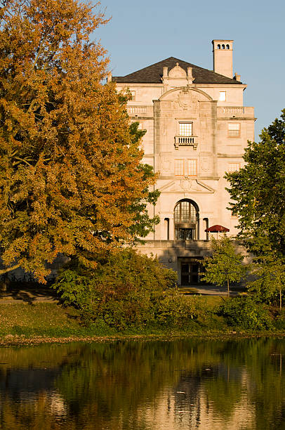 University building reflected in a pond on a sunny Fall day stock photo