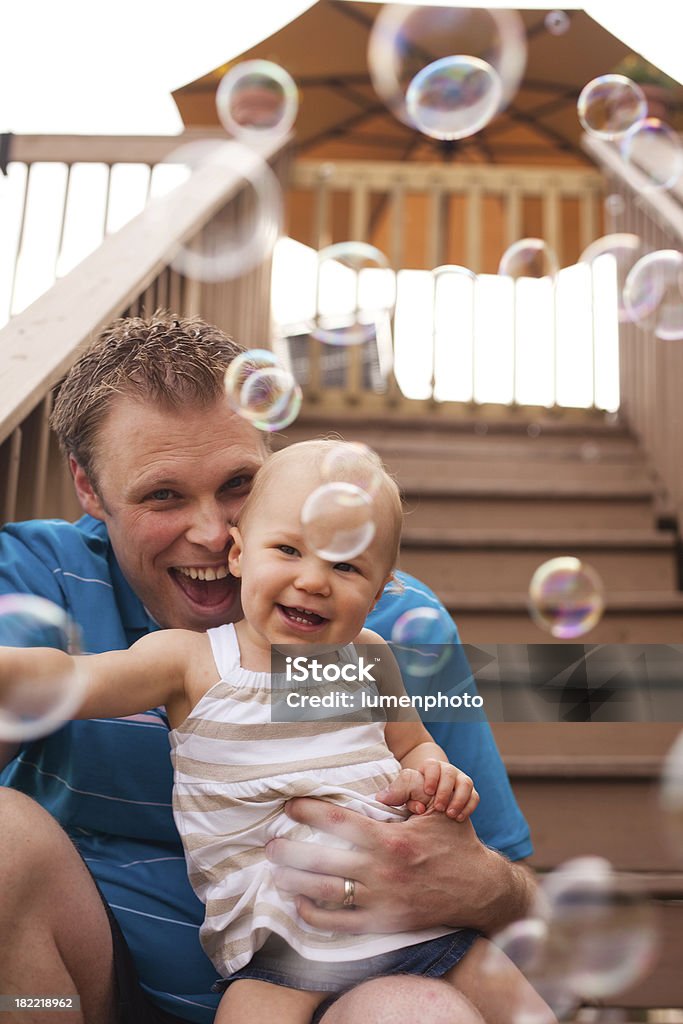 Padre tiene la sua bambina, ridendo e giocando - Foto stock royalty-free di 12-17 mesi