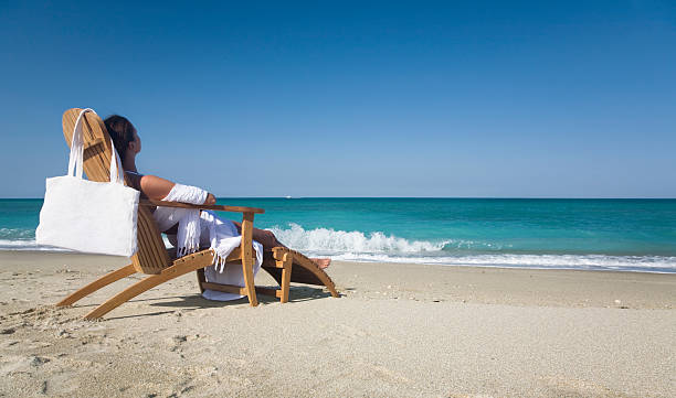 frau in einem liegestuhl - women sarong beach white stock-fotos und bilder