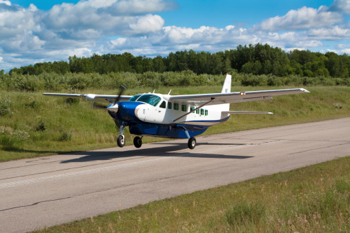 A large private airplane taking off from a remote landing strip.