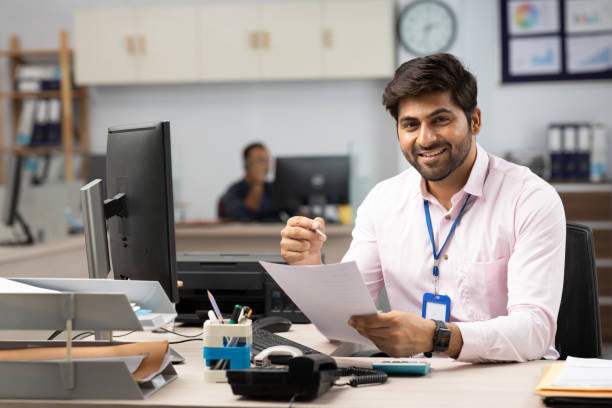 istock Businessman with Computer Reading Documents in Office stock photo 1822209866