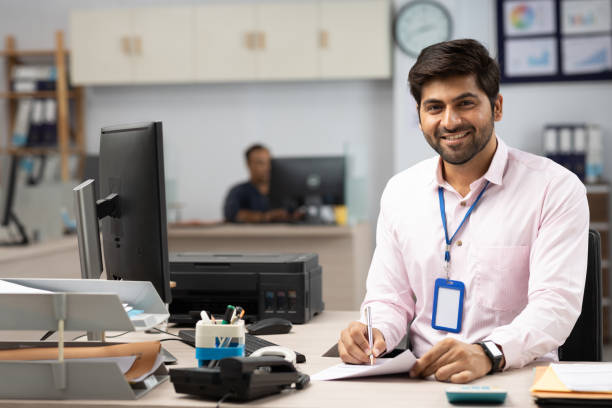 istock Businessman with Computer Reading Documents in Office stock photo 1822212048