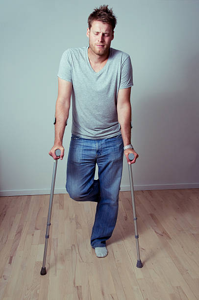 istock Young man is in pain and is supported by crutches 182221587
