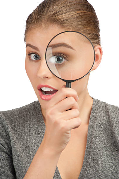 istock Woman looking through a magnifying glass 182221734
