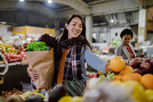 Two young smiling women shopping together at an organic bio store