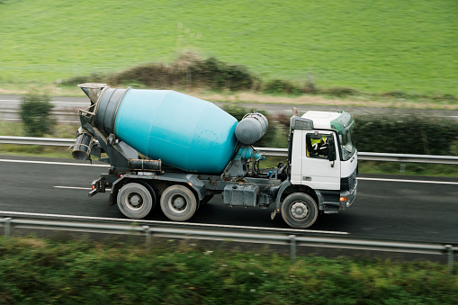 A concrete mixer truck in motion on a highway