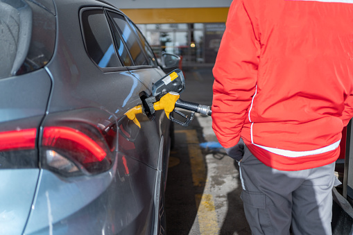 Gas Station Worker Filling Car At Gas Station