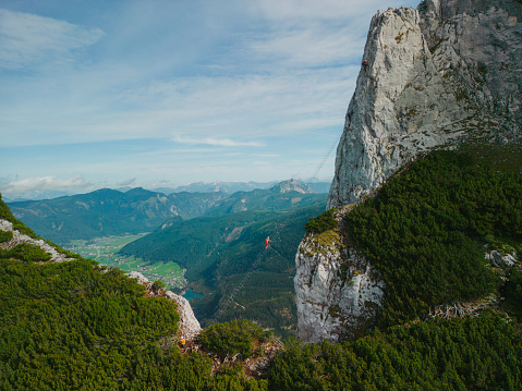Aerial view of woman climbing ladder at Donnerkogel via ferrata in Austrian Alps