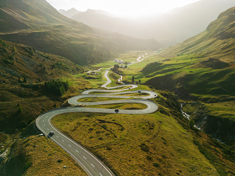 Scenic aerial view of  serpentine road (Majola Pass) in mountains  in autumn with traffic on it