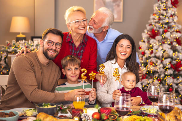 istock Multi-generation family holding balloons shaped as numbers 2024 while having Christmas dinner 1822247035