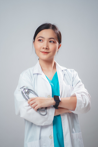 Asian woman wearing doctor uniform doctor happy smiling holding stethoscope standing isolated over white background.