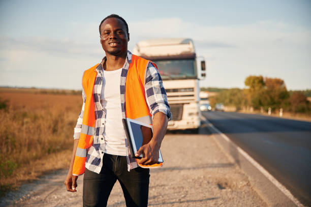 istock Front view. Black man is standing on the road with truck on it 1822269264