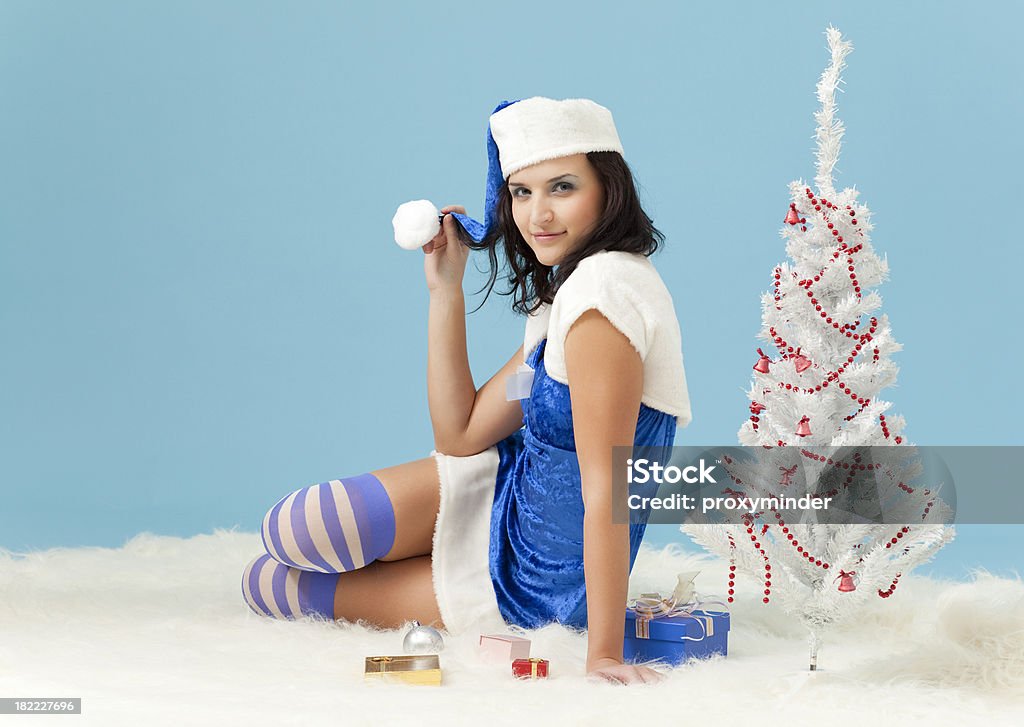 Xmas girl with Santa hat Xmas girl posing on blue background Adult Stock Photo