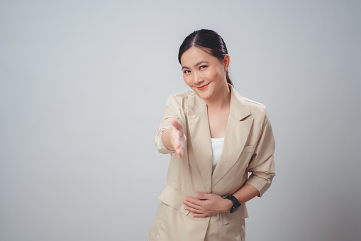 Asian woman happy giving hand make greeting gesture and looking at camera isolated over white background.