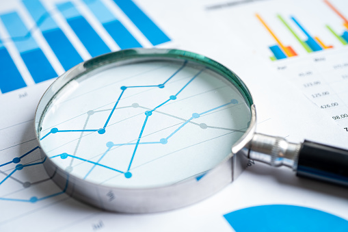 Magnifying glass on graph paper. Financial development, Banking Account, Statistics, Investment Analytic research data economy, Business concept.