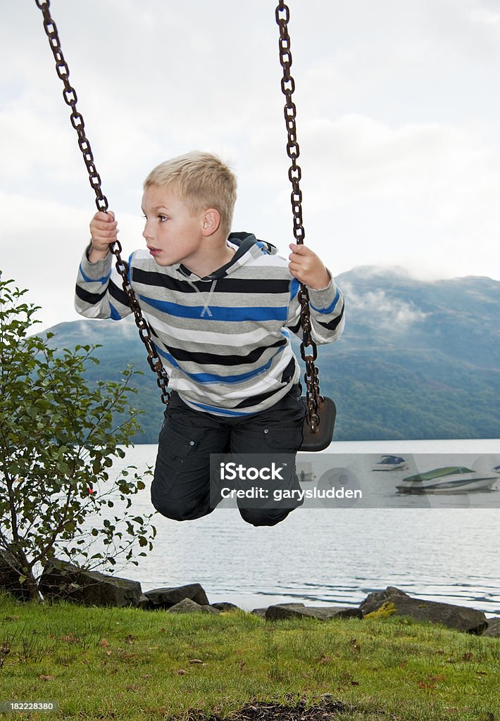 boy on swing en loch lomond shore - Foto de stock de 6-7 años libre de derechos