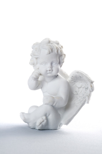 A small sitting angel on white background with shadow.