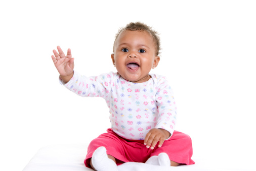 Happy baby girl waving at the camera.