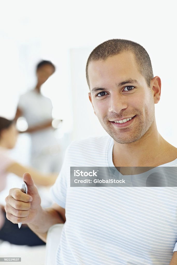 Junger Mann lächelnd mit Menschen auf der Rückseite - Lizenzfrei 20-24 Jahre Stock-Foto