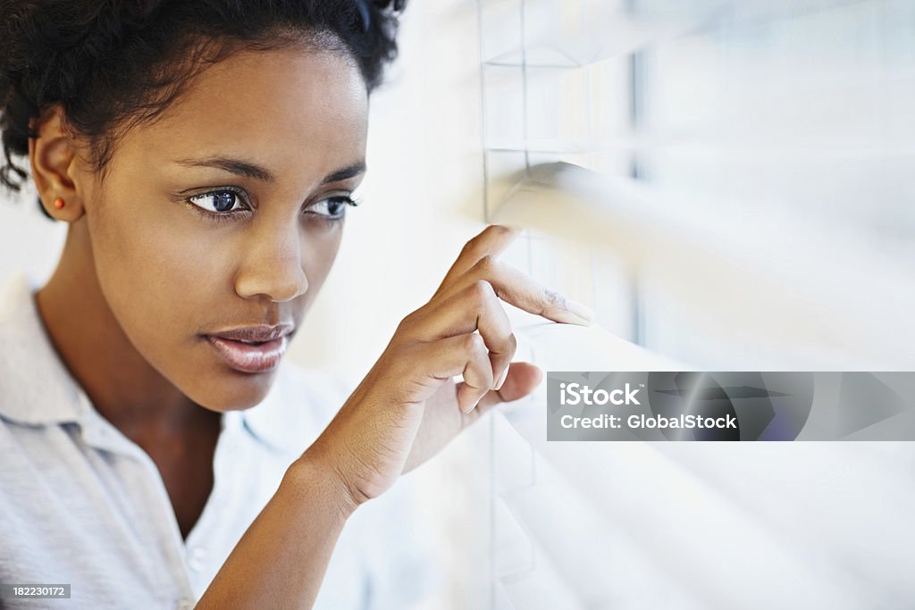 Афро-американских женщина, глядя через Жалюзи - Стоковые фото Выглядывать роялти-фри