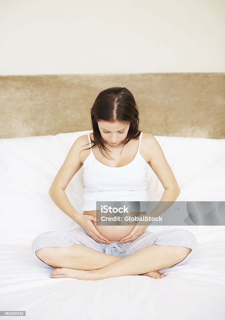 Jeune femme enceinte Femme tenant son ventre dans la chambre - Photo de 20-24 ans libre de droits