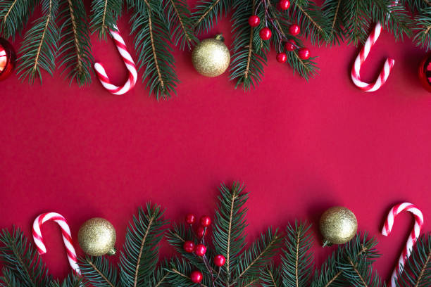 istock Christmas background with fir tree, Cristmas decorations, candy canes, with a red background. Copy space. 1822312674