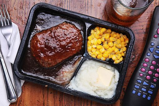 tv dinner on a tray with a remote