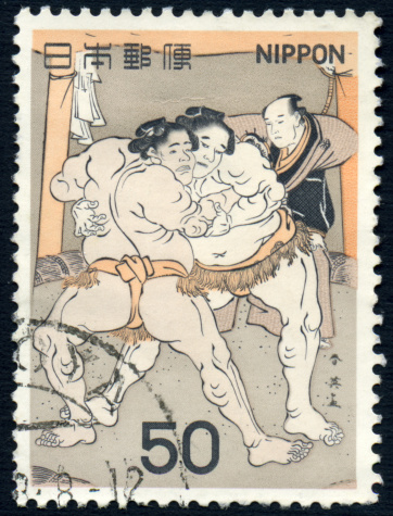 A 50 yen Japanese postage stamp issued in 1978 depicting a pair of sumo wrestlers and the referee.