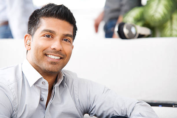 An attractive man is smiling while relaxing at home stock photo