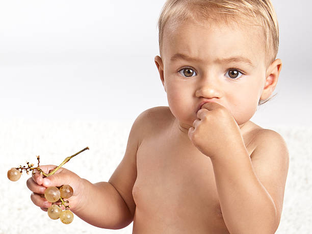 istock Baby girl eating grapes 182232852