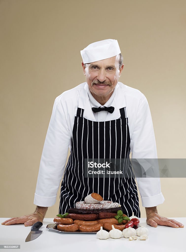 Macellaio con varietà di salsicce - Foto stock royalty-free di 40-44 anni