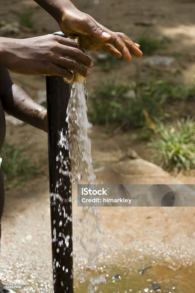 African bambini le mani intorno una pompa dell'acqua - Foto stock royalty-free di Africa