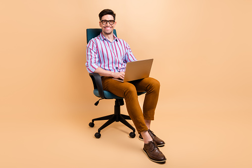 Photo of attractive cheerful man expert boss it specialist use modern gadget macbook netbook isolated on beige color background