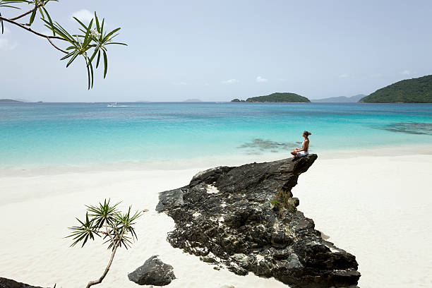 istock woman at the beach meditating 182233441