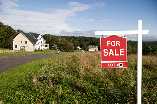 Real Estate sign showing land is for sale in a new subdivision.