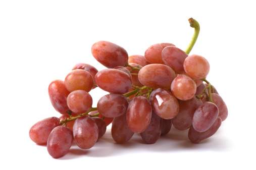 Stem of fresh red seedless grapes on white backgroundComposition is horizontal