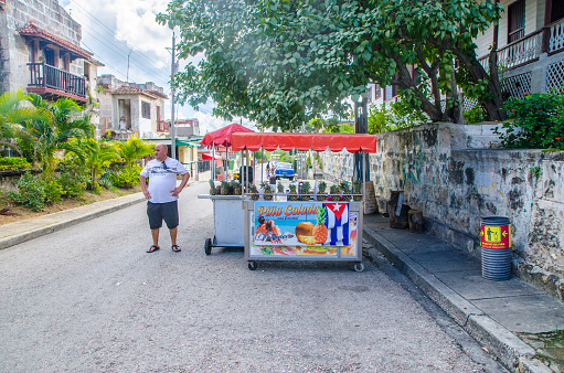 Cuban man besides his street food cart in a street of Varadero Cuba during winter day
