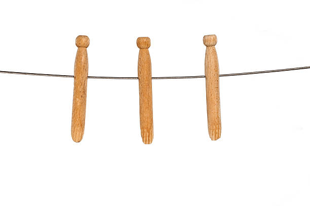 Wooden clothes pegs on a metal wire isolated on white.