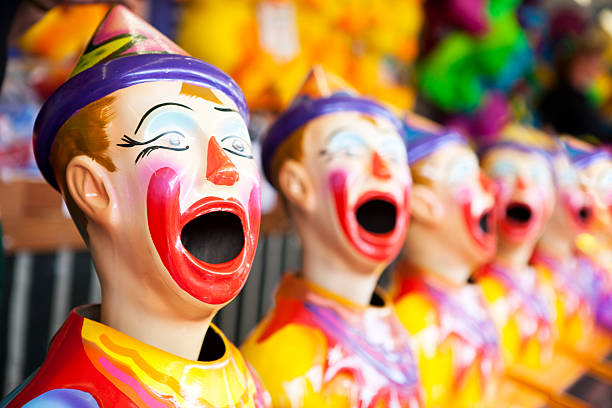 Clown head game at a fair A carnival game with a line of clowns with open mouths ready for balls. school fete stock pictures, royalty-free photos & images