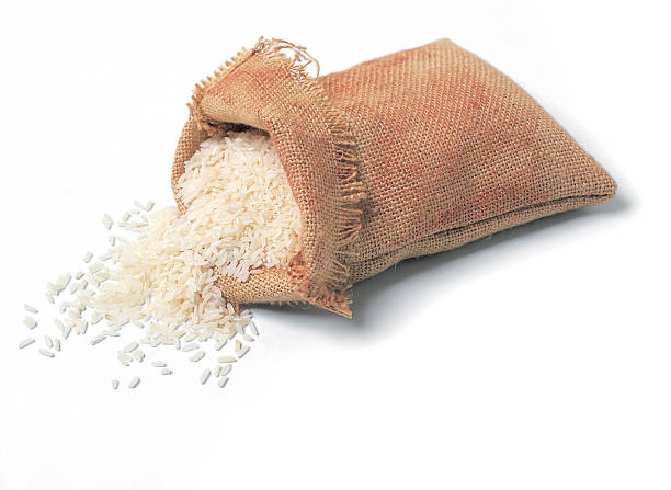 Hessian sack of rice. A hessian sack of white rice isolated on white. rice sack stock pictures, royalty-free photos & images