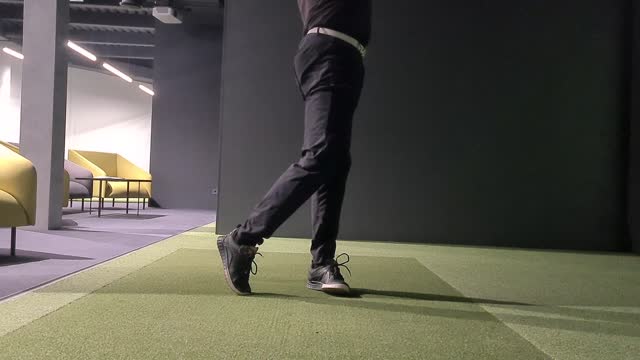 Male golfer plays golf on golf simulator indoors