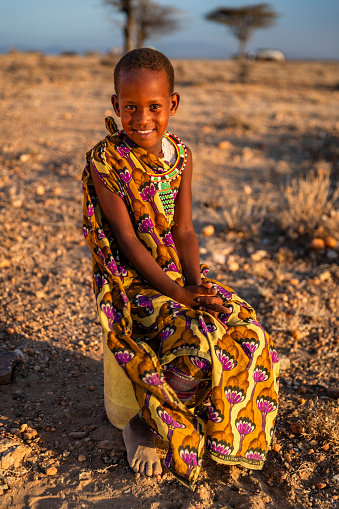 African little girl from Samburu tribe carrying water to the village, African women and children often walk long distances to bring back jugs of water that they carry on their back.  Samburu tribe is north-central Kenya, and they are related to  the Maasai.