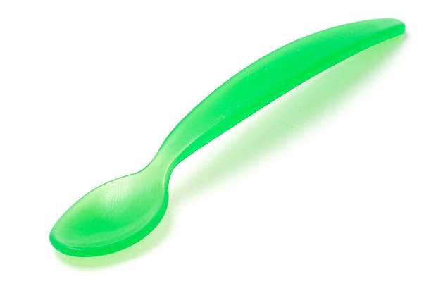 Green Plastic Spoon "A green plastic spoon for feeding babies, isolated on white." baby spoon stock pictures, royalty-free photos & images